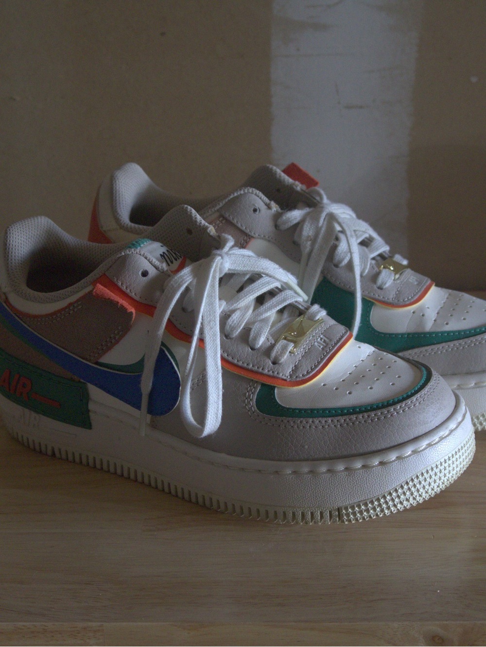 Nike Kids White Sneakers with Blue, Green, and Orange Accents